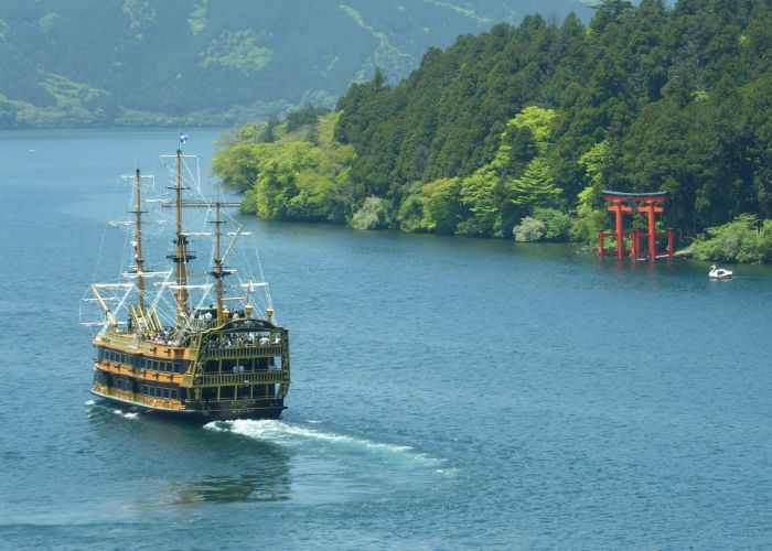 The Hakone Sightseeing Cruise crossing Lake Ashi, with the Hakone Shrine torii gate in the background.